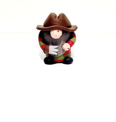 a figurine of a man with a hat and gloves sitting on the ground