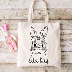 "Easter is on its way! A fun alternative to the traditional Easter basket are these adorable, personalized canvas totes. Perfectly sized for your littles one - not too big or bulky, but roomy enough for plenty of eggs and goodies!  * Sublimated in-house in our shop in Louisiana * Cotton/linen tote bag * Enter personalization in provided space * 12\" wide X 14\" tall * Ready to ship or pickup in 1-2 business days" Cute Rectangular Canvas Bag For School, Cute Rectangular Canvas Bags, Cute Letter Print Canvas Bag For School, Cute Canvas Bag With Letter Print For School, Cute School Canvas Bag With Letter Print, Cute Canvas School Bag, Cute Canvas Bag For Back To School, Cute Canvas Bags For Back To School, Cute Customizable Bags For Daily Use