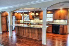 an empty kitchen and living room with wood flooring in the middle of it is shown