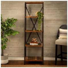 a wooden shelf with plants and books on it in front of a gray painted wall