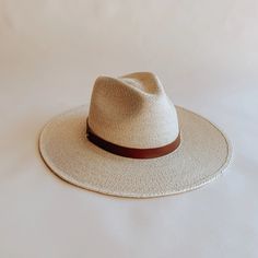 The Soleil straw fedora was thoughtfully designed to be an approachable, ready to wear style that effortlessly tops off any warm weather outfit. Featuring a flat, stiff brim size that measures 3 1/2", and a classic pinch crown fedora shape, the Soleil shines for everyday wear, offering UPF 50+ sun protection. Sustainably harvested tripilla palm straw is lightly toasted, then intricately handwoven by artisans in Puebla, Mexico to create each Soleil style, part of our premium straw hat collection. Adding to the versatility of our headwear, the Soleil's removable and interchangeable, genuine leather hatband with its gold hardware finish has become a Leah hat signature. Available with an adjustable inner, cotton sweatband for a more comfortable fit. Each hat comes with a genuine brown leather Natural Boater Hat With Flat Brim For Everyday, Everyday Natural Boater Hat With Flat Brim, Toquilla Straw Hat With Flat Crown For Vacation, Flat Crown Toquilla Straw Hat For Vacation, Classic Panama Hat With Flat Brim For Everyday, Classic Flat Brim Panama Hat For Everyday, Vacation Hat With Flat Crown In Toquilla Straw, Summer Fedora With Adjustable Flat Crown, Summer Fedora With Short Brim For Everyday