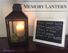 a lit candle sitting on top of a wooden table next to a sign that says, this candle burns in loving memory of those who are forever present in our hearts