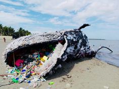 a boat that has been washed up on the beach with plastic bottles all over it