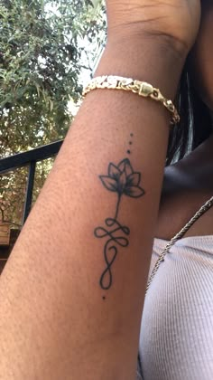 a woman's arm with a tattoo on it and a flower in the middle