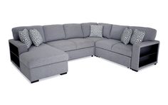 a gray sectional couch with pillows on it