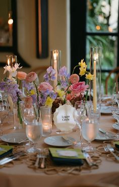 the table is set with flowers and candles