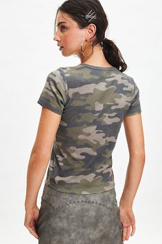 '90s baby tee vibes with this soft and stretchy cropped top complete with NYC graphic at the chest. Only at Urban Outfitters. Features NYC 1990 graphic baby tee Soft and stretchy baby tee Camo print tee NYC graphic at the chest Bodycon fit Cropped length UO exclusive Content + Care 100% Cotton Machine wash Imported Size + Fit Model in Green Multi is 5’10.5" and wearing size Medium Measurements taken from size Medium Chest: 28" Length: 21" | NYC 1990 Graphic Camo Baby Tee in Camo, Women's at Urba Urban Outfitters Stretch T-shirt With Short Sleeves, Fitted Graphic Tee From Urban Outfitters, Fitted Tops With Graphic Print And Scoop Neck, Scoop Neck Top With Graphic Print And Stretch, 90s Graphic Print Stretch Crop Top, 90s Stretch Crop Top With Graphic Print, Urban Outfitters Graphic Print Short Sleeve Top, Urban Outfitters Grunge Tops For Summer, Urban Outfitters Summer Grunge Tops