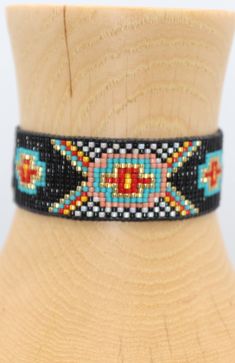 Introducing our southwestern cross cuff bracelet- perfect for adding a touch of boho chic to any outfit! This bracelet is handmade with black leather trim and colorful seed beads, and features an adjustable closure for a perfect fit. It is beaded on strong beading thread & flexible natural leather for comfortable stylish look. It can be worn alone or stacked with other pieces. 7/8 of an inch wide. This bracelet will fit a 6-8 inch wrist. When you purchase this bracelet, I make it to order, just Beading Thread, Beaded Cuff Bracelet, Loom Bracelets, Bead Loom, Beaded Cuff, Natural Leather, Leather Trim, Leather Trims, Cuff Bracelet