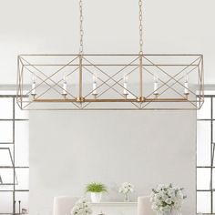 a dining room table and chairs with candles on the chandelier