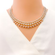 This exquisite 18k gold necklace set, weighing 59.0 grams, features a chic design adorned with dazzling diamonds. The combination of rose and white gold enhances its luxurious appeal, making it perfect for any special occasion. The set includes a necklace with a total diamond weight of 9.97 carats, featuring F-G color and VS quality diamonds in round shapes. The necklace has a length of 17.25 inches with adjustable 0.75-inch links and is secured with a hook lock. The matching earrings, each meas Dazzling Rose Gold Diamond Necklace With 17 Jewels, Dazzling Rose Gold Diamond Necklace For Weddings, Rose Gold Fine Jewelry Diamond Necklace For Wedding, Rose Gold Diamond Necklace With Brilliant Cut For Wedding, Rose Gold Diamond Necklace For Wedding, Rose Gold Brilliant Cut Diamond Necklace For Wedding, Formal Rose Gold Jewelry Sets With Diamond Accents, Exquisite Rose Gold Diamond Necklace With Accents, Exquisite Rose Gold Diamond Necklace For Anniversary