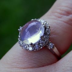 a close up of a person's hand holding a ring with an amethorate