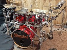 a red drum set sitting on top of a wooden floor