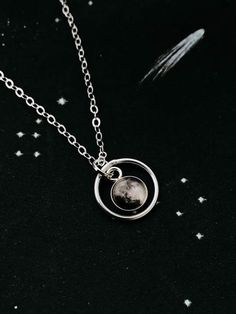 "This delicate pendant is positively darling. This petite necklace is available in sterling silver or 14k gold and is personalized with the moon phase that had been in the sky during an important occasion in your life! Was it the day you were born? Married? Had children? A life-changing experience? Whatever the moment, there was a phase of our moon shining down on it. This itty bitty moon hangs in the middle of a delicate gold or silver halo. To order, please provide the following information in Engraved Moonstone Round Jewelry, Round Engraved Moonstone Jewelry, Engraved Round Moonstone Jewelry, Dainty Silver Moon Shaped Jewelry, Silver Moon Charm Necklace For Gift, Moon Shaped Sterling Silver Jewelry For Mother's Day, Celestial Moon Shaped Birthstone Jewelry, Celestial Moon-shaped Birthstone Jewelry, Celestial Sterling Silver Personalized Necklaces