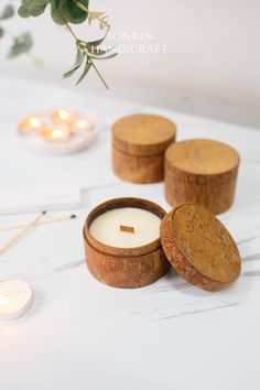 three wooden containers with candles on a table