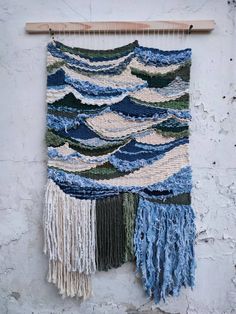 a wall hanging made out of blue and white yarn