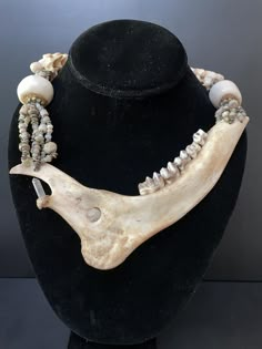 Deer Jaw Bone Necklace, Symbolizes the gentle, enticing lure of new adventures. Modern Sacred Tribal Talisman. Made By Teresa Bradford Length: 19" Jaw bone length: 7"  Weight 180 grams    *Excavated African Trade Mali Glass Seed Beads Nigerian Silver spacers, Polished Bone accent Round chunky bobbles Snake Vertebrae, Carved bone closure. *Vintage Small African Lost Wax Brass Spacer Beads, African Brass Spacer Beads, Hand made in the Ashanti region of Ghana  *Closure, Carved Camel Bone Double Dorjie Handmade Button.  *Upholstery Thread Strung on Upholstery Nylon is a heavyweight 100% nylon thread for machine and hand sewing indoor and outdoor heavyweight fabrics. It is a bonded 3-ply nylon thread that is weather abrasion mildew and UV-resistant.    *Throughout the world, Deer symbolizes ten Viking Bone Jewelry, Fish Bone Jewelry, Nordic Shaman, Animal Bone Jewelry, Snake Vertebrae, Primitive Jewelry, Bone Accessories, Talisman Jewelry, Earthy Jewelry