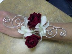 a person's arm with flowers on it and two silver rings attached to the wrist