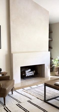 a living room filled with furniture and a fire place in the middle of the room