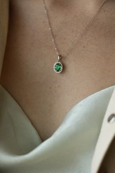 Sometimes the garnet is greener on the other side... if it is a stunning Tsavorite, that is! This one of a kind Garnet pendant on an adustable 16-18" chain just glows withe a dainty halo frame of 20 tiny diamonds. 14k White Gold, 2.21gr .89ct Natural Tsavorite Garnet .12cts Natural VS Diamonds Garnet Pendant Necklace, Elegant Oval Tsavorite Jewelry, Green Emerald Jewelry With Halo Detail, Green Emerald Halo Jewelry, Green Emerald Necklace With Halo Setting For May Birthstone, May Birthstone Green Emerald Necklace With Halo Setting, May Birthstone Emerald Necklace With Halo Setting, Oval Green Tsavorite Jewelry, Emerald Pendant Necklace With Halo Setting