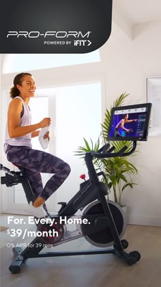 a woman is riding an exercise bike in the living room