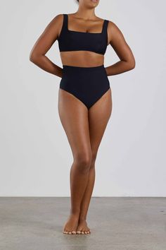 The Lola Bikini Top in Black is chic and understated. Designed to flatter and support the bust it is made using our technically advanced Sculpteur® fabric. With a minimal, square neckline and comfortable wide shoulder straps to provide extra support for larger busts, the top features panels and removable bra cups to enhance and define the bust's profile. Part of our Signature Collection, Lola is supremely comfortable, elegant and flattering for the ultimate in body confidence. Perfect for cup si Full Coverage Sculpting Smoothing Swimwear, Black Sculpting Swimwear For Swimming, Sculpting Solid Swimwear With Built-in Bra, Shapewear Bandeau Swimwear With Built-in Bra, Sleek Brief Swimwear, Sleek Swimwear With Bra-friendly Minimal Stretch, Seamless Bandeau Shapewear Swimwear, Fitted Swimwear With High-cut Leg And Moderate Back Coverage, Full Coverage Sculpting Swimwear With Seamless Construction