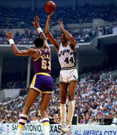 two men playing basketball in front of an audience