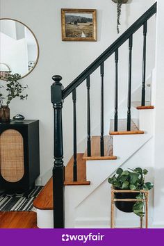 there is a black and white stair case next to the bannister in this house