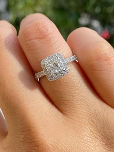 a close up of a person's hand with a diamond ring on their finger