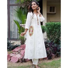 White pure cotton kurta set with hand embroidery details. Size Chart THESE ARE GARMENT MEASUREMENTS (IN INCHES)  XSSMLXLXXL Chest343638404244 Waist303335373941 Hip363840424446 Shoulder13.51414.51515.515.5 Kurta Length484848484848 Pants Length393939393939 Embrace your mesmerizing look with this crafted White Embroidered Cotton Anarkali Kurta with Pants Set. The White Cotton Anarkali kurta has embroidery, a round neckline and 3/4th sleeves. The White cotton pants have embroidery and both of them h Spring Cotton Silk Kurta With Embroidered Border, White Cotton Silk Salwar Kameez For Spring, Traditional Cotton Silk Anarkali Set For Spring, Festive Floral Embroidered Kurta For Navratri, Traditional Spring Anarkali Set In Cotton Silk, Festive Floral Embroidery Kurta For Navratri, Traditional Cotton Silk Kurta For Spring, Chanderi Kurta With Floral Embroidery For Navratri, Off White Embroidered Kurta For Festive Occasions