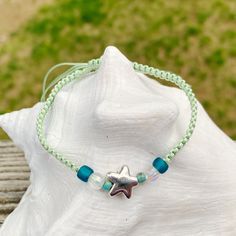 Cute nylon cord friendship bracelet with a metal star charm and accent beads. The size is adjustable and fits to almost any wrist. Can be worn in water. Interested in seeing more? Please check out my store: https://www.etsy.com/shop/OxfordCommaStore Custom requests always welcome! Adjustable Star Bracelets For The Beach, Casual Adjustable Beaded Bracelet With Star Charm, Casual Adjustable Starfish Beaded Bracelets, Adjustable Beaded Bracelets With Star Charm For Friendship, Beach Braided Bracelets With Nylon Cord, Adjustable Nylon Cord Beaded Bracelets For Beach, Beach Beaded Bracelets With Sliding Knot, Green Waxed Cord Friendship Bracelets For Beach, Summer Bracelet