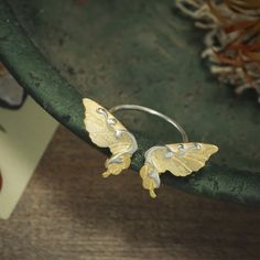 Crafted from sterling silver with a gleaming finish, the Dancing Butterfly Ring is the perfect addition for any jewelry collection. Its exquisite design is inspired by the beauty of nature, making it an enchanting accessory for any occasion - from special gifts to everyday wear. This exquisite piece of jewelry will have you feeling like the queen of your own enchanted garden. DETAILS Plating: 18k Gold  Materials: 18k Gold on Silver Size:  Adjustable Silver  Weight:  2.81g Butterfly Accessories Jewelry, Silver Butterfly Nature-inspired Jewelry, Nature-inspired Sterling Silver Butterfly Jewelry, Gold Sterling Silver Butterfly Ring, Silver Butterfly Jewelry, Butterfly Engagement Ring, Garden Details, Cuban Link Chain Necklaces, Opal Pendant Necklace