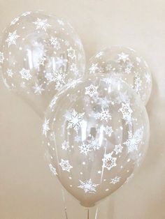 three clear balloons with snowflakes on them