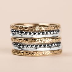 Introducing The Demi Stack, a set of seven unique and beautiful stacking rings that are perfect for making a bold statement. Made with mixed metals in gold fill and sterling silver, each ring features a different texture, from raw silk to mirror hammered. Mix and match them to create your own unique look. Whether you're dressing up or dressing down, these rings are sure to add a touch of edge and coolness to any outfit. USA sizes 4-12. Made with high quality materials, these rings are built to last. The set includes 3 14K yellow gold fill heavy weight "Raw Silk" stackers, 2 sterling silver "Dot" stackers, and 2 Sterling silver "Mirror" stackers. So whatever your style, you're sure to find the perfect combination with this set. PRODUCT DETAILS & MEASUREMENTS: - 100% Handmade in the USA. - M Fusion Style Stackable Ring Jewelry, Fusion Style Stackable Round Jewelry, Fusion Style Stackable Round Rings, Unique Stackable Rings For Everyday, Unique Hammered Stackable Rings For Promise, Unique Hammered Stackable Rings For Anniversary, Rings In Gold, Ring Bands, Tarnish Remover