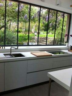 a kitchen with an open window overlooking the garden