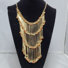 Gold Fringe Chain Necklace With Gold And Orange Beads Metal Beaded Necklaces With Dangling Beads, Beaded Metal Dangle Chain Necklace, Metal Beaded Chain Necklace For Gift, Gold Beaded Metal Necklaces, Orange Costume Jewelry Necklace For Party, Gold Beaded Chain Metal Necklaces, Gold Metal Beaded Chain Necklace, Gold Bib Necklace With Colorful Beads, Orange Beaded Dangle Necklaces