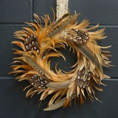 a wreath made out of feathers hanging on a wall