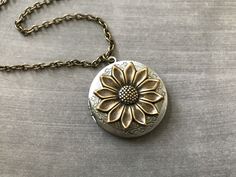 Antique Brass Sunflower Locket Necklace... The locket I used to create this charming necklace is an antique silver plated floral brass photo locket. I attached an antique brass sunflower stamping to the center. The antique brass cable chain has soldered links and is a non tarnish chain that closes with a lobster claw clasp. This is the sweetest locket and would make a perfect gift for your girlfriend! Locket - 1.25 inches in diameter OR (31.75mm) Interior photo area - 25mm Chain - 24 inches long Silver Brass Locket Necklace For Anniversary, Flower Locket Necklace For Gift, Antique Flower Necklaces For Weddings, Vintage Flower Necklaces For Anniversary, Vintage Antique Silver Locket Necklace For Wedding, Vintage Antique Silver Locket Necklace Nickel Free, Vintage Jewelry With Flower Charm For Anniversary, Vintage Nickel Free Antique Silver Locket Necklace, Wedding Metal Locket Necklace