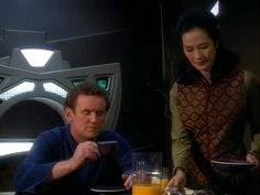 two people sitting at a table with plates of food and drinks in front of them