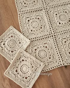 three crocheted place mats on a wooden floor