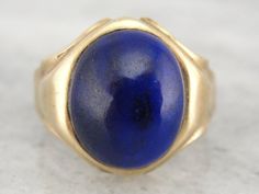 "Suitable for a man or a woman, thanks to it's moderate size, this vintage ring features a high domed, perfectly polished cabochon of deep blue lapis lazuli. Metal: 10K Yellow Gold Gem: Lapis Lazuli Gem Measurements: 14.3 mm x 11.8 mm, Oval Size of Ring: 9 1/4 but can be sized to fit almost any finger (please see our sizing policies for more information). Marks: \"10K\" on inside band W21AQN-P Each piece has been identified and graded by a Graduate Gemologist who has been certified by the Gemolo Classic Domed Yellow Gold Sapphire Ring, Classic Yellow Gold Domed Sapphire Ring, Classic 14k Gold Sapphire Oval Cabochon Ring, Formal Cabochon Signet Ring, Classic Yellow Gold Sapphire Ring Oval Cabochon, Classic Formal Cabochon Sapphire Ring, Classic Formal Sapphire Cabochon Ring, Formal Fine Jewelry Signet Ring With Cabochon, Classic Cabochon Sapphire Ring For Formal Occasions