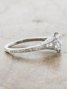 an antique style engagement ring with a diamond center