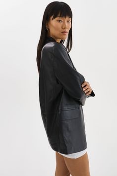 Indulge in the timeless elegance of the QUIRINA Leather Blazer, a quintessential addition to every discerning wardrobe. Crafted with a peaked lapel design and adorned with classic flap pockets, this blazer exudes sophistication and versatility. Its unlined construction ensures a feather-light feel, ideal for navigating transitional seasons with ease. Pair it effortlessly with jeans and a tee for an understated yet chic ensemble, or channel refined professionalism with the YAREN Leather Pants and Classic Leather Jacket With Lapel Collar And Concealed Placket, Classic Leather Jacket With Notch Lapel, Classic Leather Jacket With Notch Lapel And Pockets, Tailored Leather Jacket With Notch Lapel, Leather Blazer With Pockets For Work, Tailored Leather Jacket With Notch Lapel And Pockets, Sleek Single Button Blazer Dress For Formal Occasions, Classic Leather Jacket With Welt Pockets For Business, Notch Lapel Leather Jacket With Pockets