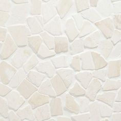 a white stone wall that has been made with different shapes and sizes, including small rocks