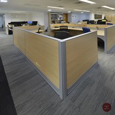 an empty office cubicle with desks and chairs