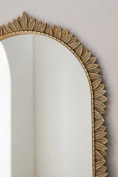 an ornate gold mirror hanging on the wall