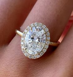 a woman's hand with a diamond ring on top of her finger and an engagement band