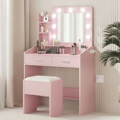 a pink vanity with lights on it and a stool