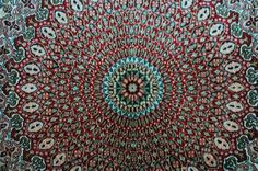 an intricately designed rug is shown in red, green and blue colors with skulls on it