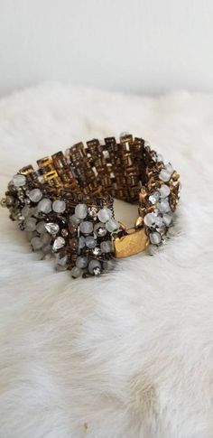 This is a vintage 1930s statement bracelet. The back is a bronze tone metal and shows some signs of wear from age. The front is a mixture of many decorative materials. There are teardrop shaped crystal tone gems, filigree metalwork in the bronze tone, pearl tone beads, flowers, vines, and leaves in the bronze tone metal. There are also milky tone hand-rolled glass beads, rhinestone tone beads and butterfly wing shapes from the bronze tone metal. The bracelet is in excellent condition.Measurement Butterfly Wing Shapes, Wing Shapes, Flowers Vines, Butterfly Wing, Wedding Jewelry Bracelets, Wedding Anniversary Gift, Vintage Bridal, Statement Bracelet, Anniversary Gift For Her