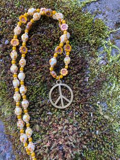 "Peace sign pendant hung from a summery strand of Czech glass beads. The strand is 17\" long and the pendant is about .75\" long HANDMADE WITH LOVE.  Each color, type of stone or material and design are thoughtfully put together and personally hand strung by me. Every piece of jewelry I make is unique and one of a kind, so you'll have something no one else has! Please know that in the stills and videos you see I try hard to show the true colors and details of my pieces using natural light. Howev Yellow Beaded Necklace For Summer Gifts, Bohemian Beach Flower Necklace With Round Beads, Bohemian Flower Necklace With Round Beads For Beach, Gold Bohemian Beads For Summer, Yellow Flower Necklace For Summer, Summer Yellow Flower Necklaces, Summer Yellow Flower Necklace, Summer Yellow Beaded Necklaces With Large Beads, Yellow Beaded Necklaces With Large Beads For Summer